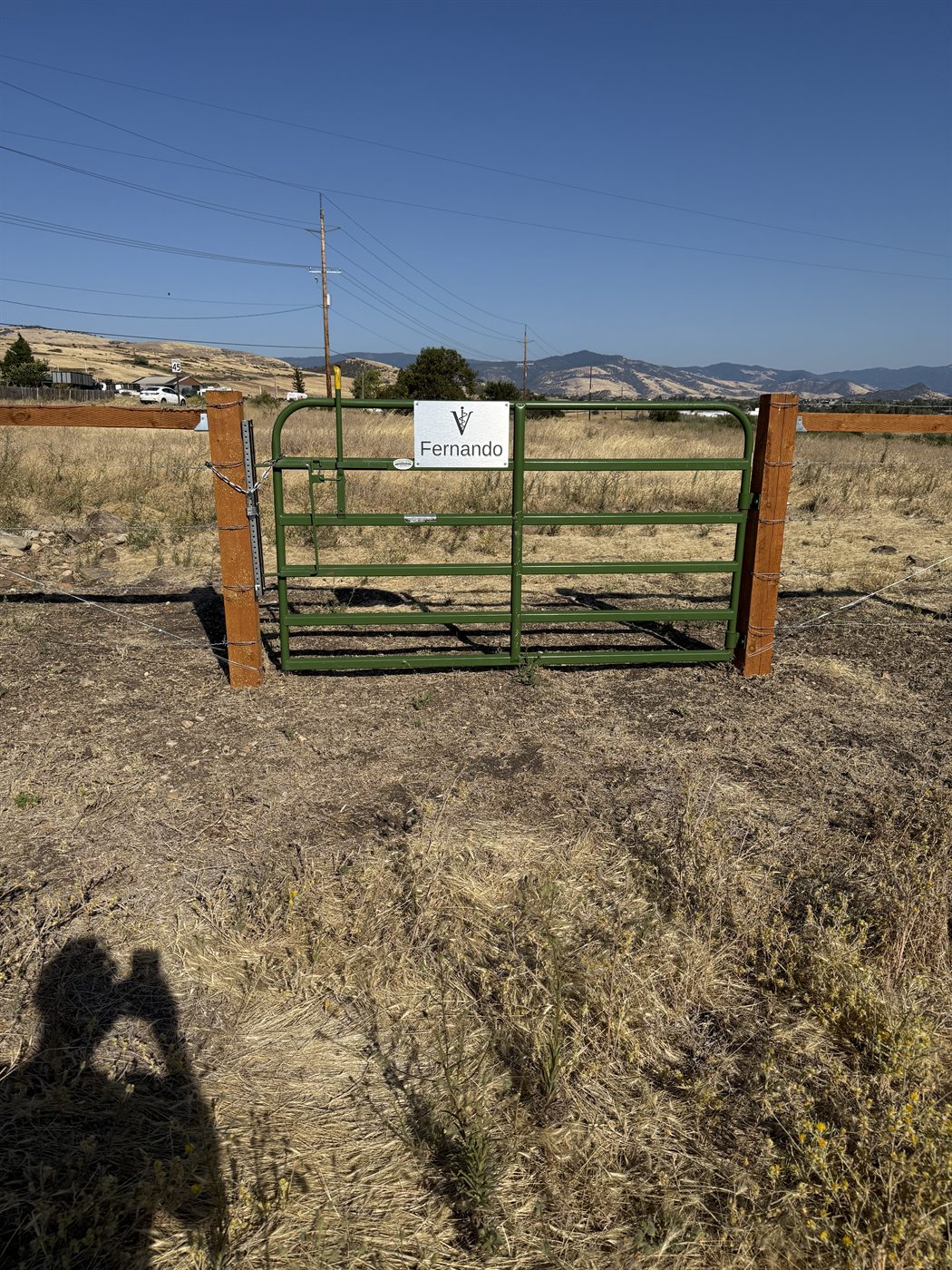 Donor gate sign reading Fernando on a pasture gate with the Rogue Valley behind it